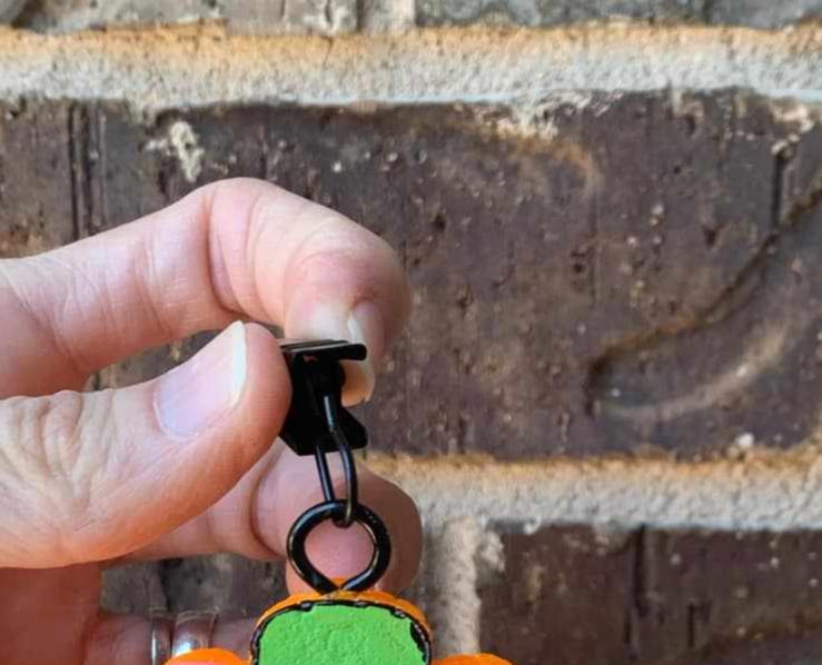 hand holding black metal vent clip hook