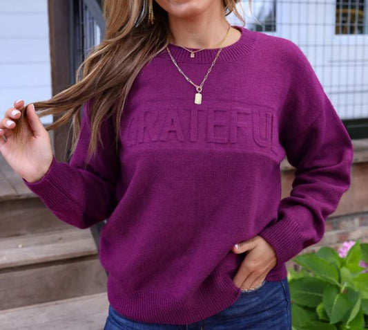 eggplant grateful sweater embossed on a woman wearing jeans and a gold necklace