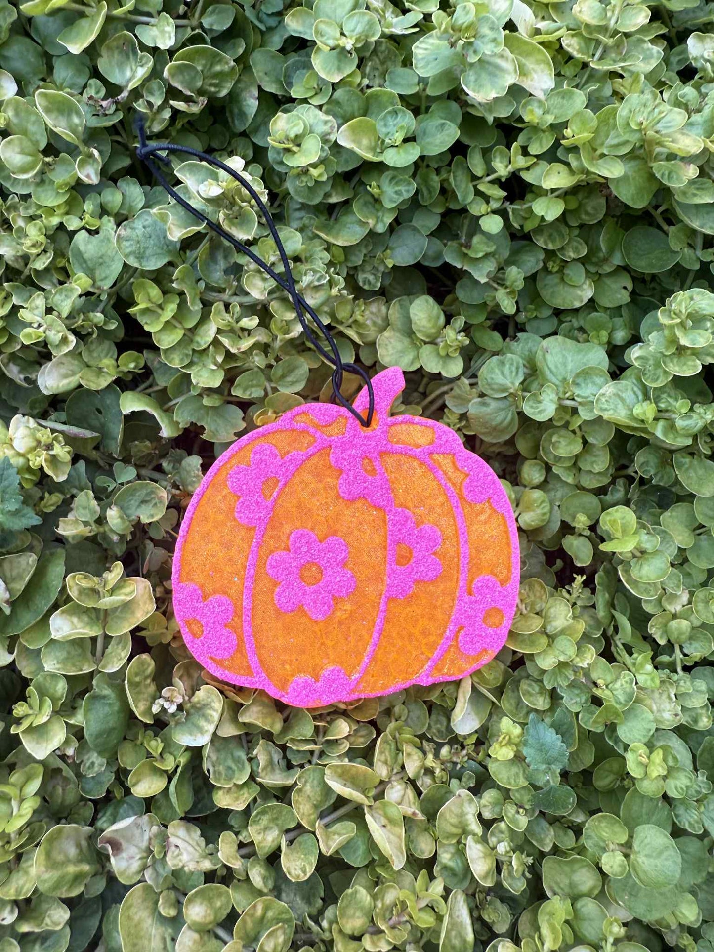 Orange pumpkin freshie with pink daisies. Greenery background