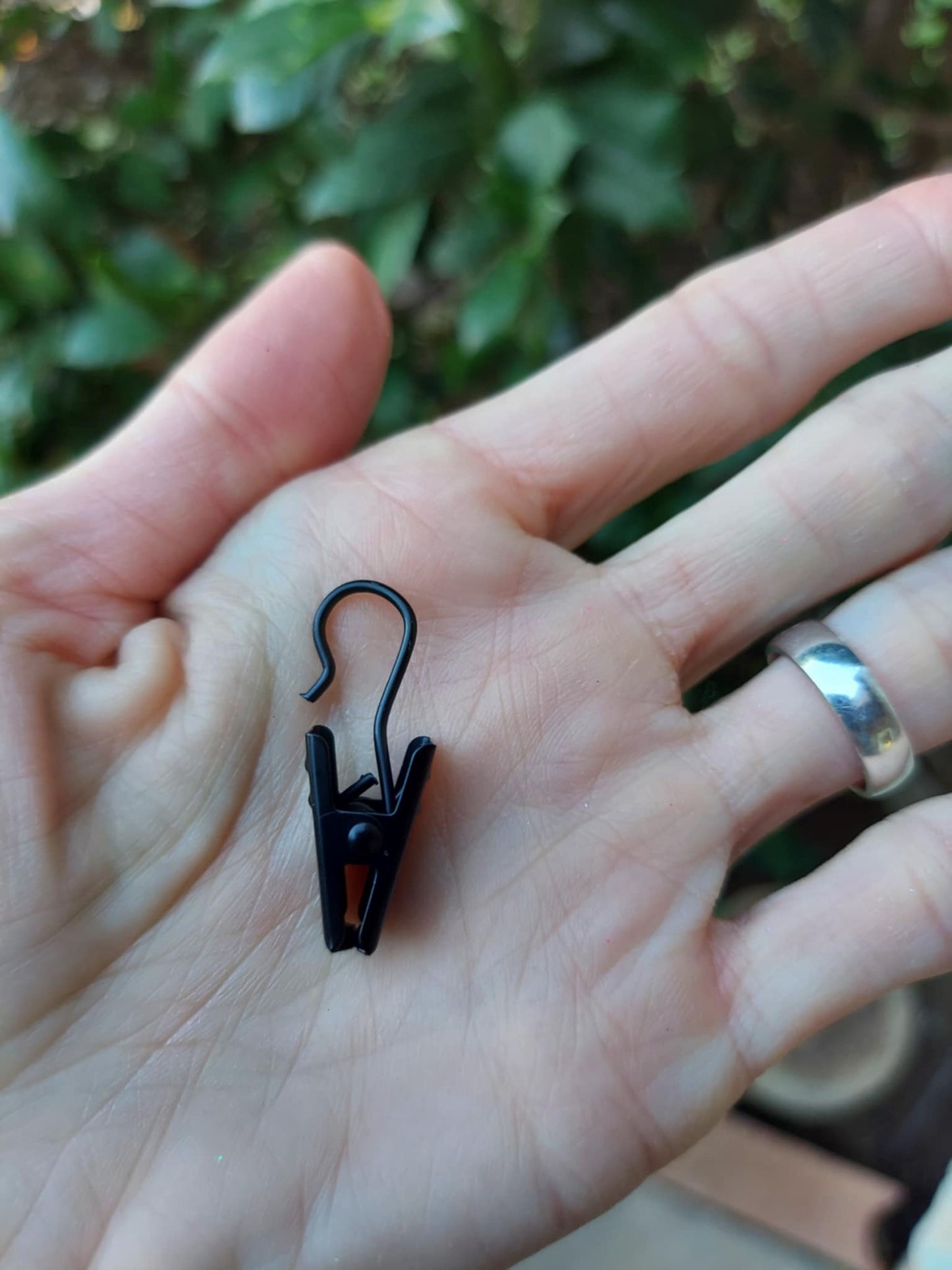 hand holding a black metal vent clip