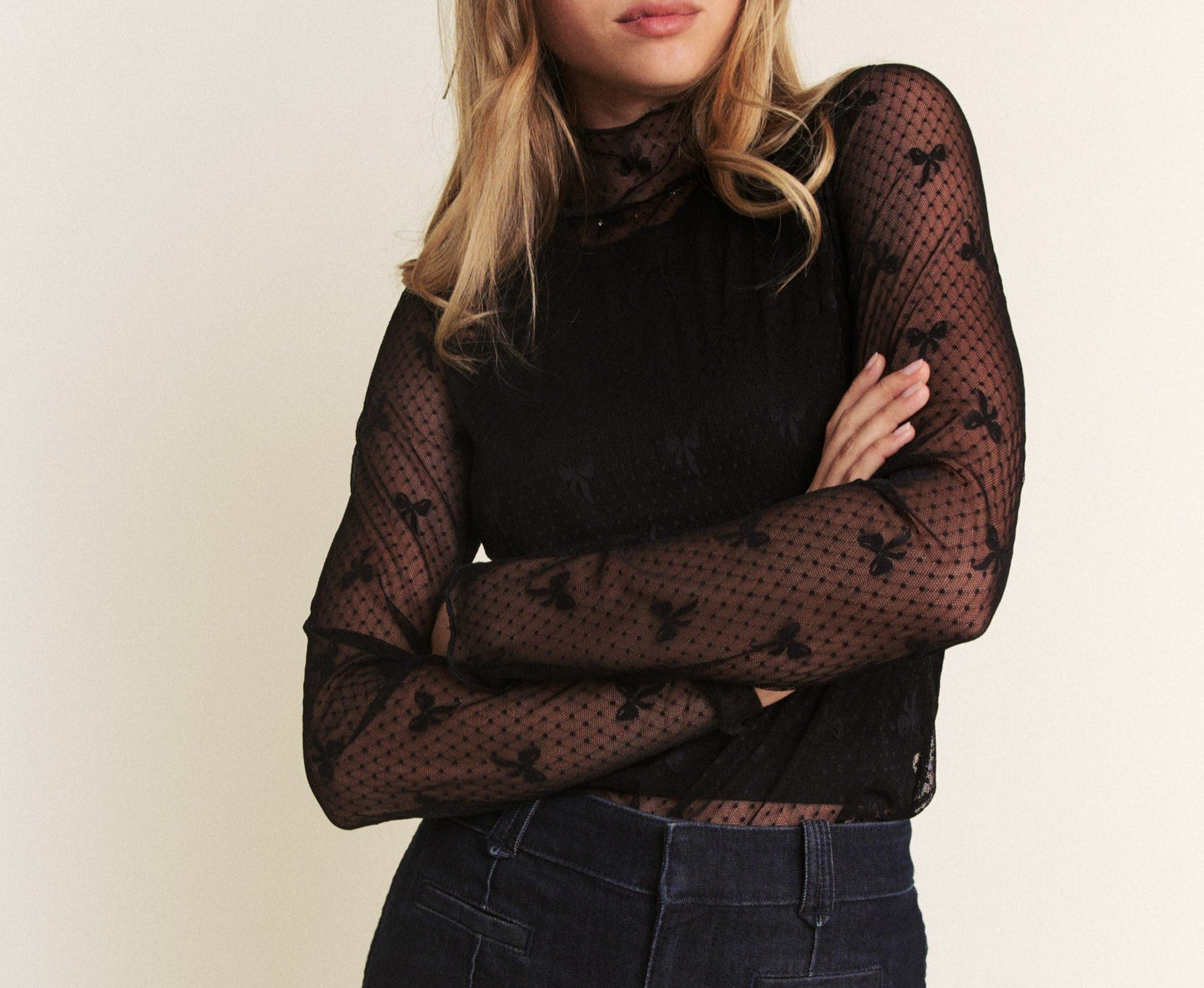 black bow print mesh top on woman. White background