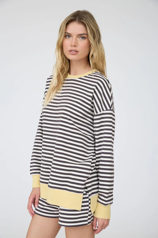 side view of a charcoal striped knit top and shorts on a woman standing against a white background