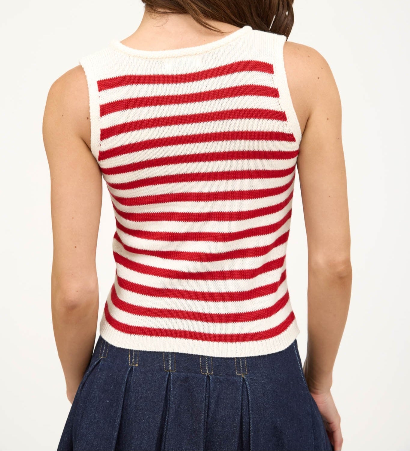 Person wearing a red and white striped sleeveless top on a plain background. Back view