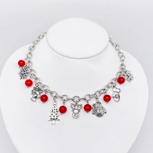 Silver chain necklace with red bead-like charms and various Christmas-themed metal charms, displayed on a mannequin bust.