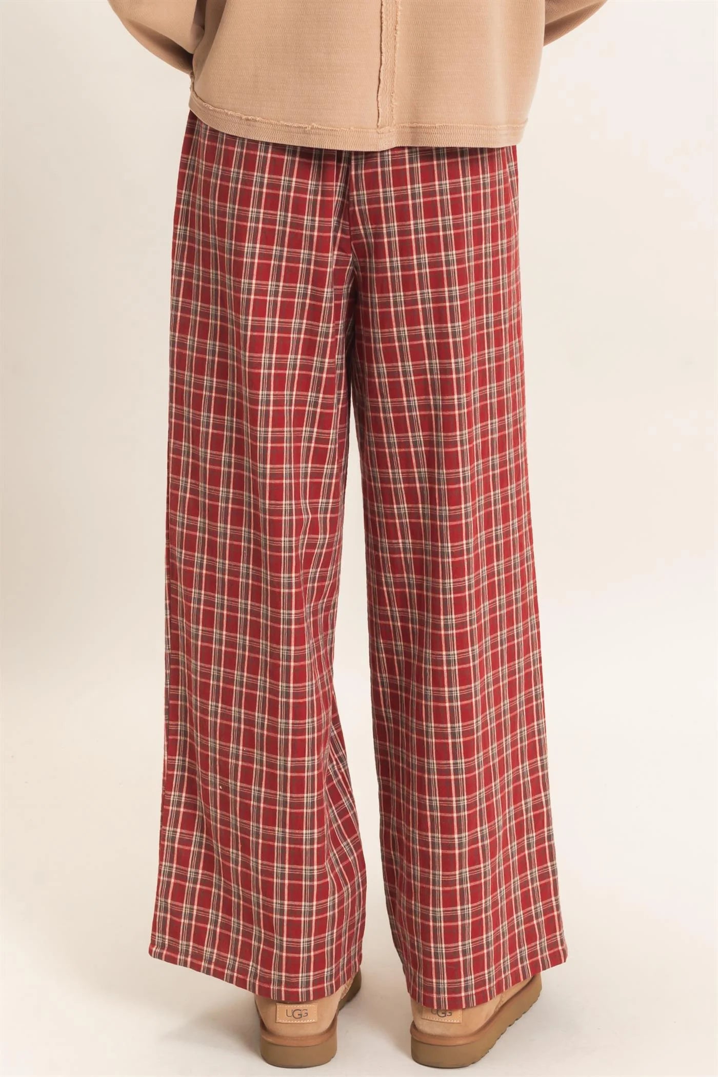 Red plaid pants worn by a person on a beige background