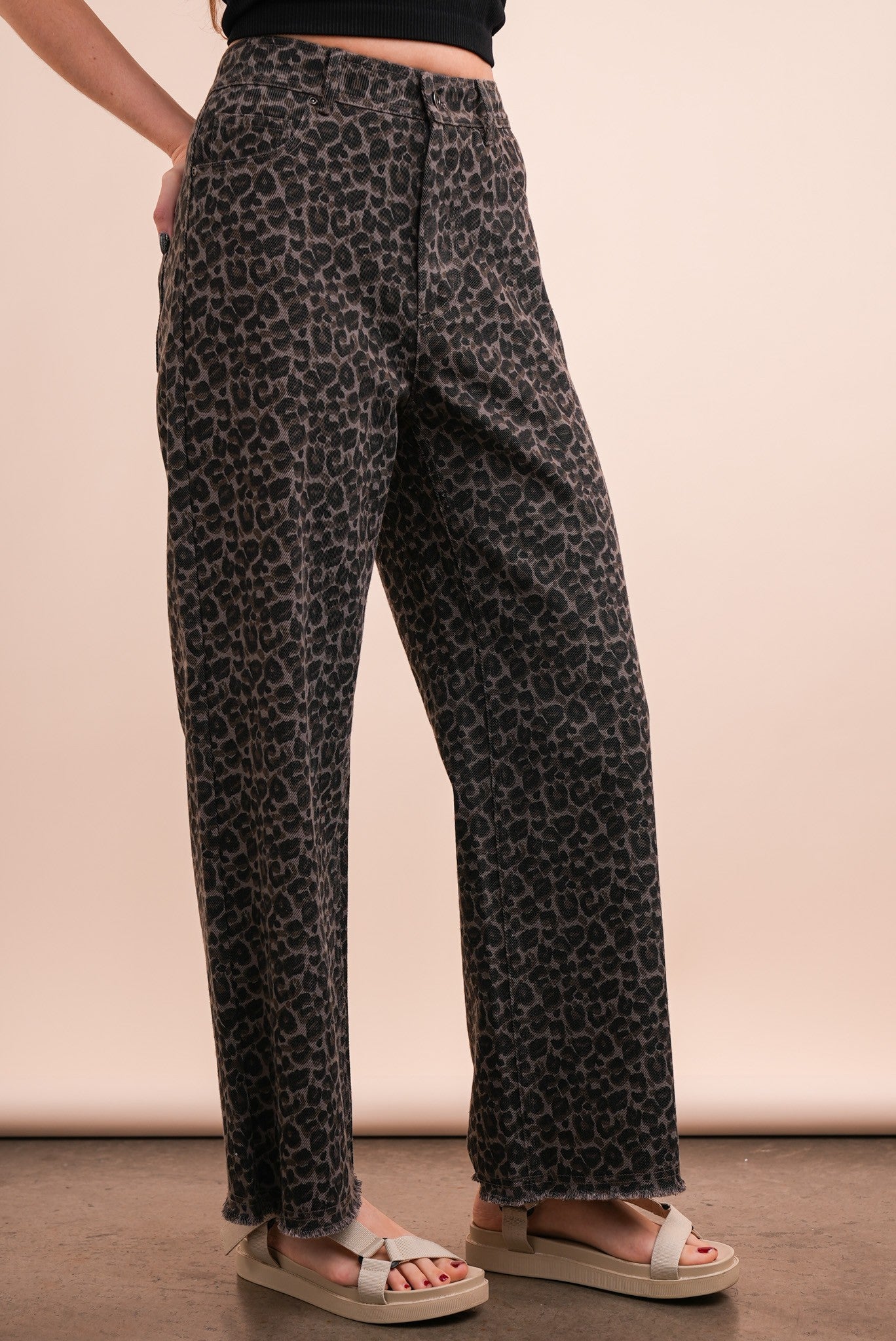 person wearing leopard jeans and sandals, side view