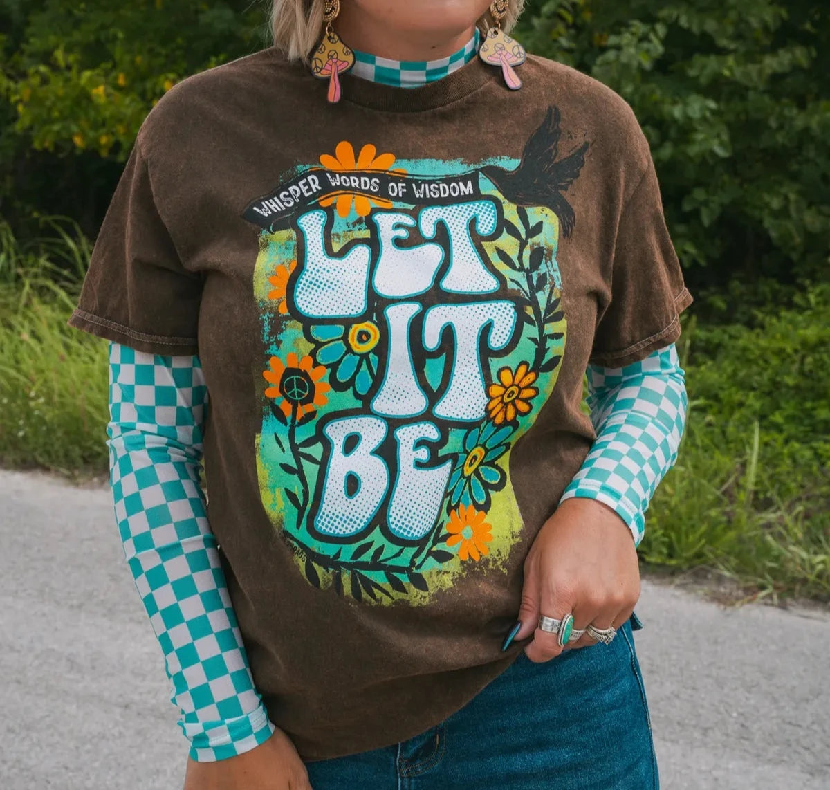 person wearing let it be tee with a green background