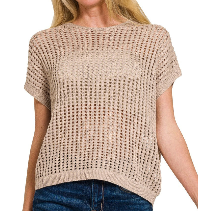 woman wearing light mocha sweater vest and jeans on a white background