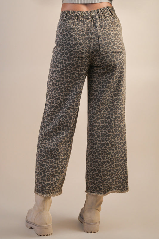 back view of model wearing mocha leopard jeans and boots on beige background