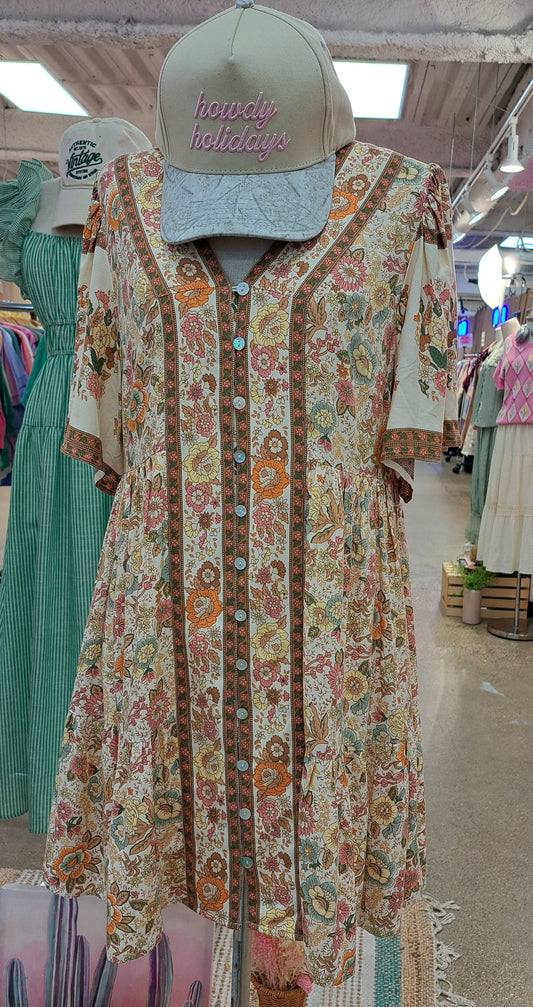 Floral dress on a mannequin in a store setting with various items in the background.