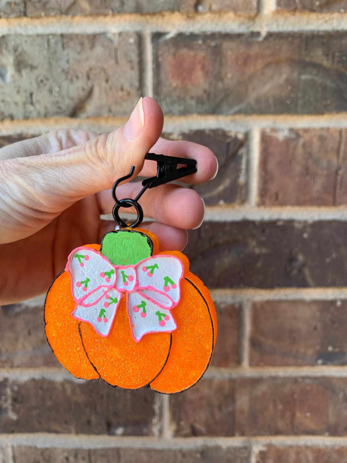 pumpkin vent clip in hand on a black metal hook
