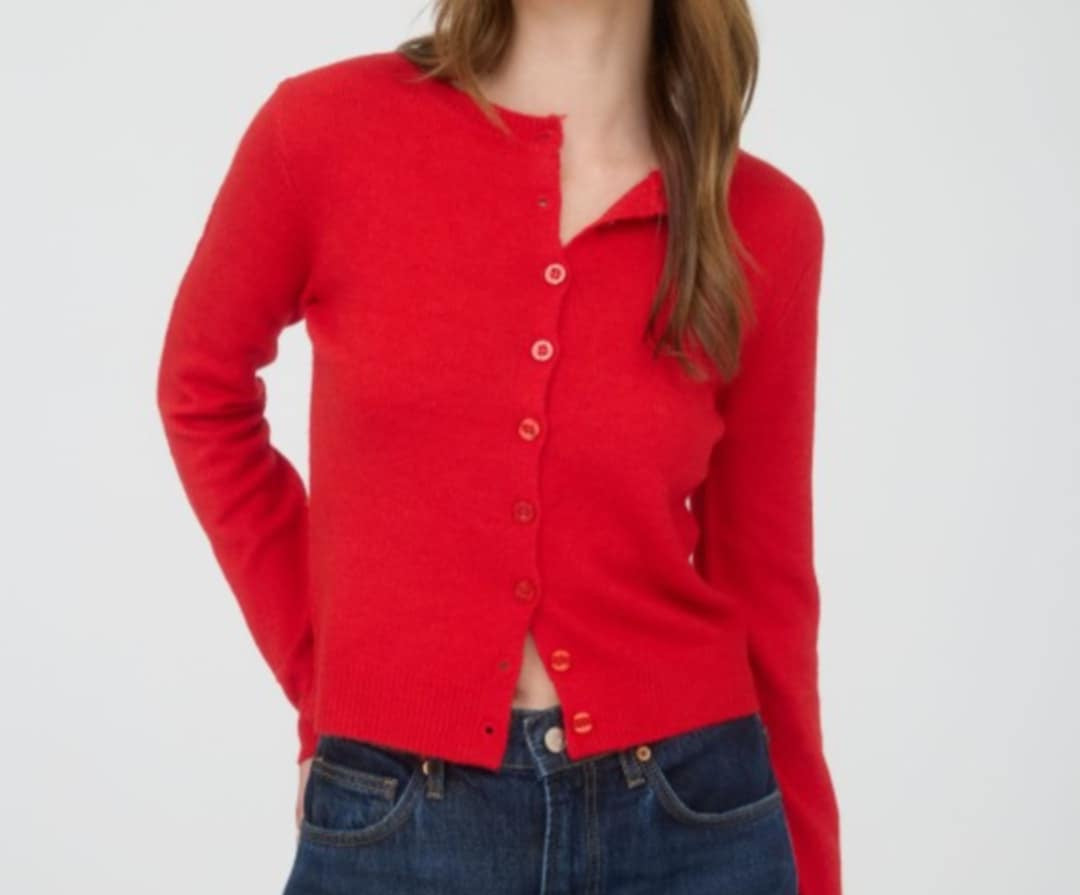 Red cardigan worn by a person on a white background