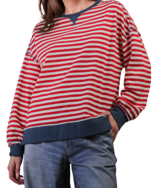 Woman wearing a red and cream striped sweater on a white background