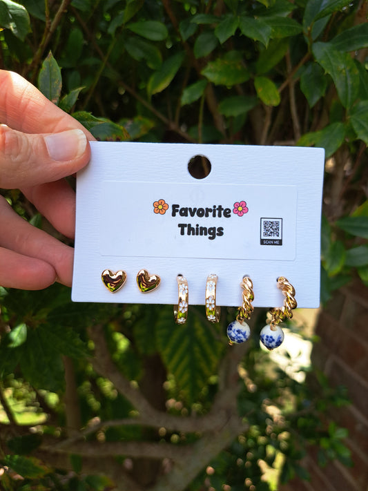 Set of earrings on a 'Favorite Things' card held in front of a green leafy background