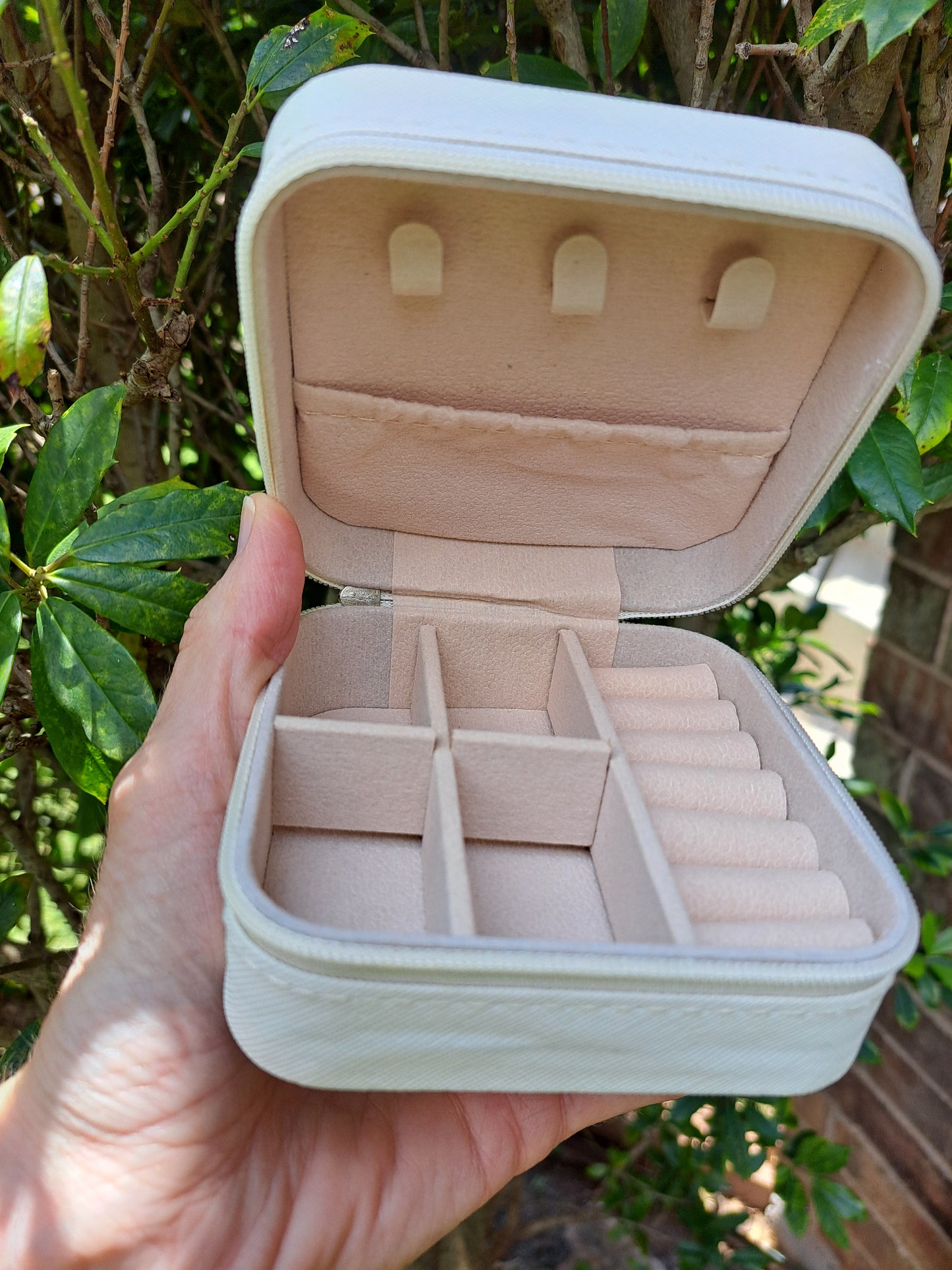 Inside pockets of a small jewelry box on green background