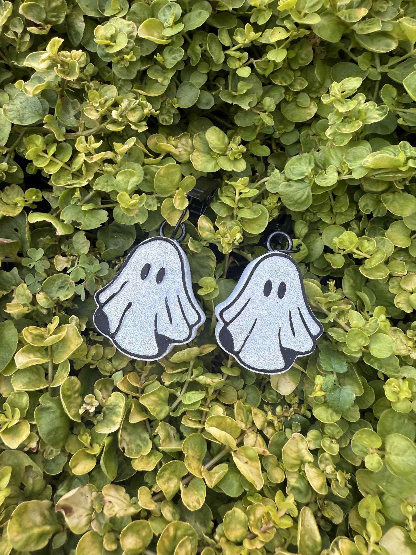 white ghost vent clips with black trim. Greenery background