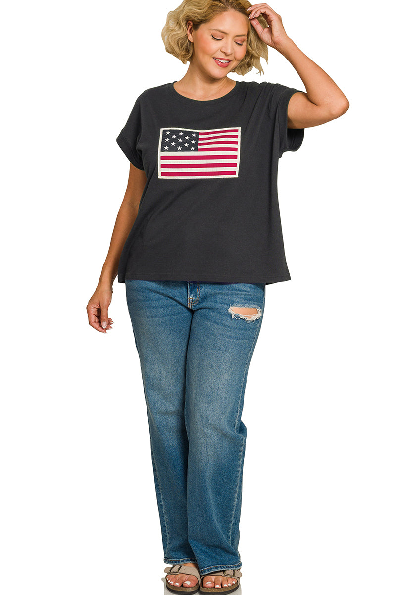 Woman wearing a black t-shirt with an American flag design and blue jeans on a white background