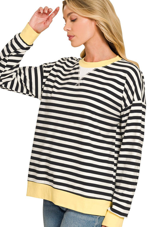 woman wearing a black and white striped pullover top with yellow trim