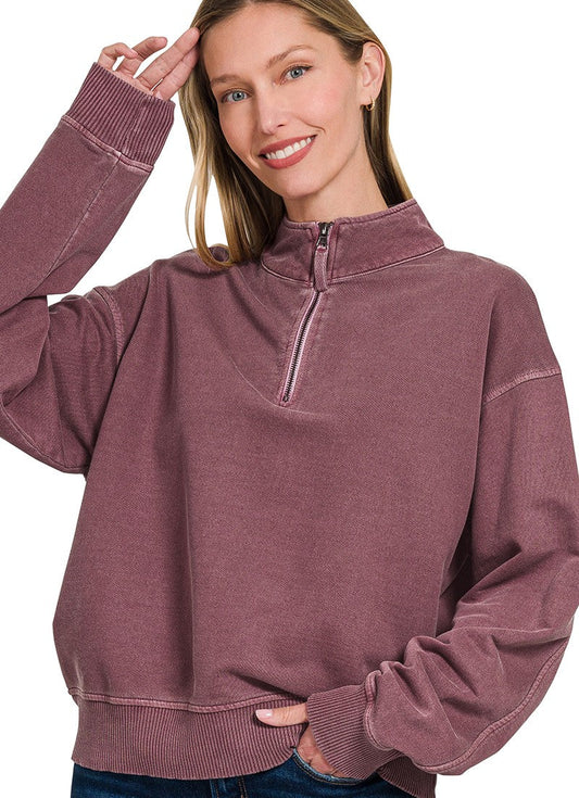 Woman wearing an eggplant-colored pullover with a quarter zip on a white background
