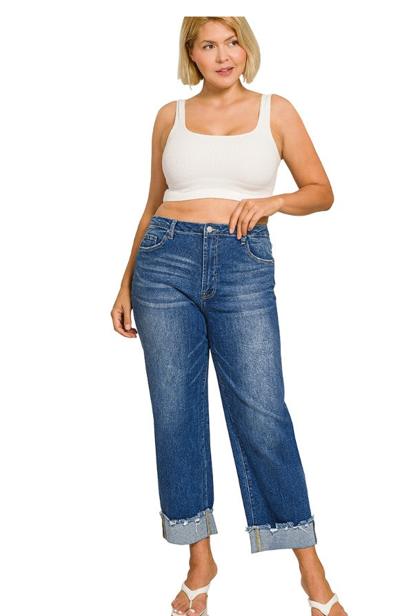 Woman wearing blue jeans and a white tank top on a white background