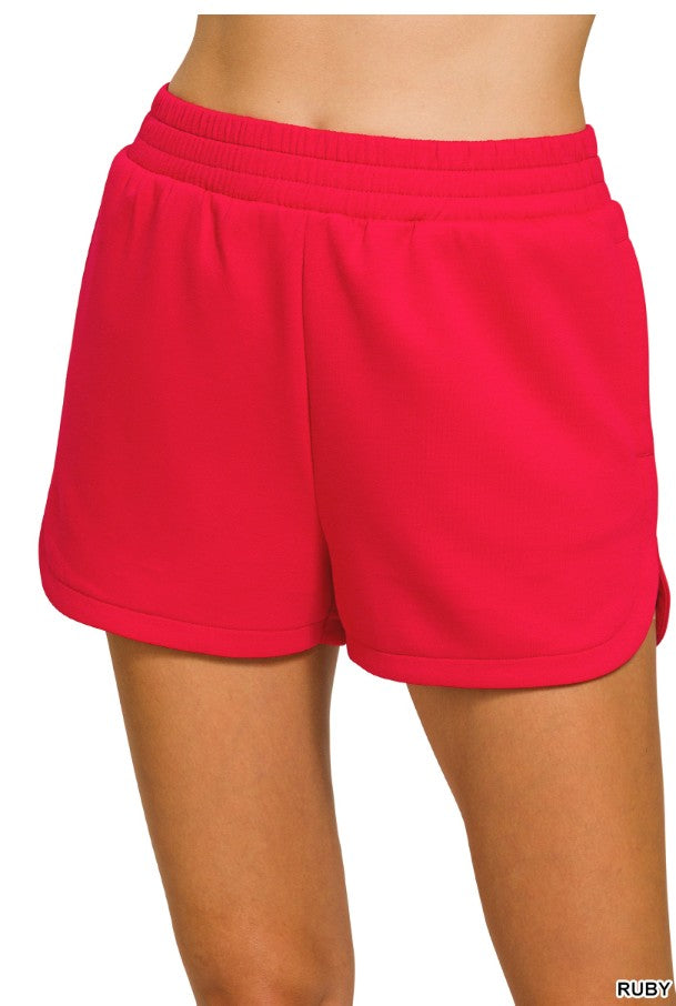 Red shorts worn by a person on a white background
