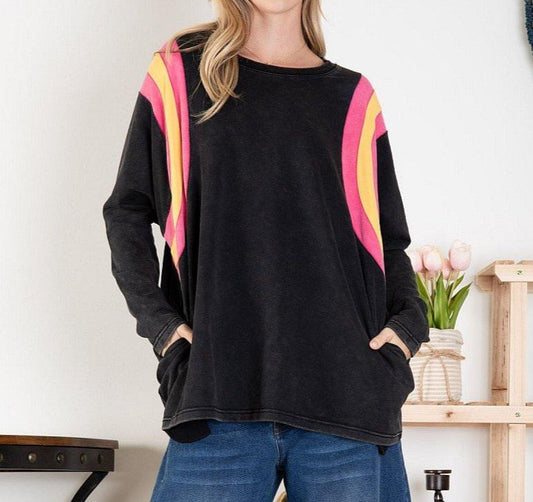 Black stonewashed knit top with orange and pink sholder stripes on a woman with a white background