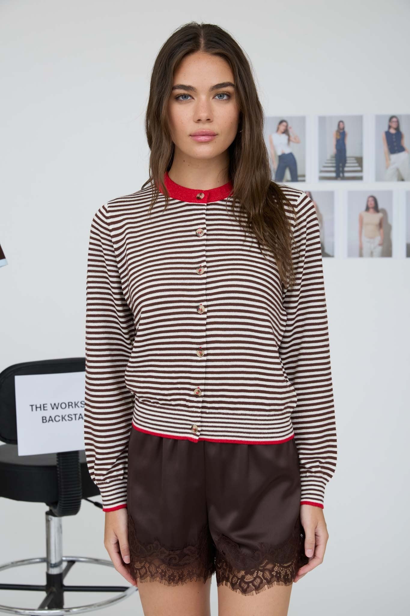 Woman wearing a striped cardigan and lace shorts in an indoor setting.