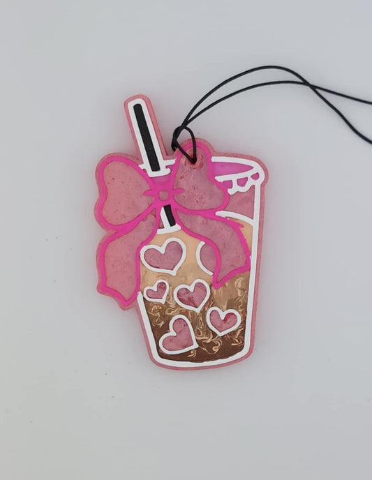 A pink heart-shaped boba with a pink bow and a black straw, designed as a air freshener. White background