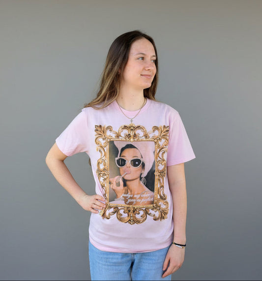 Woman wearing a pink tee against a neutral background