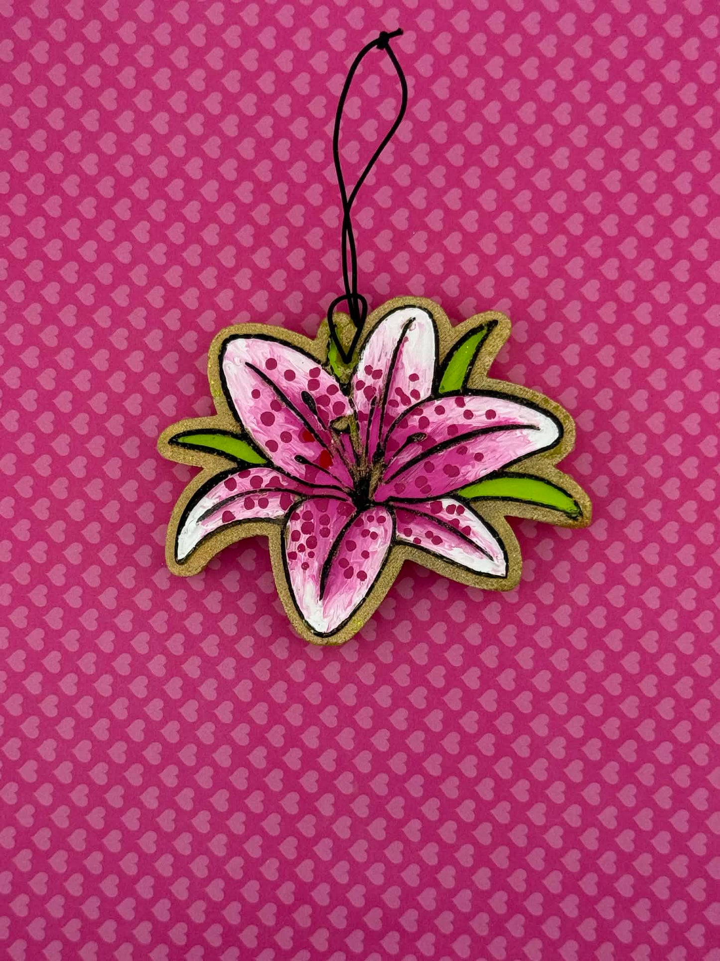 Lily shaped freshie on a pink background with heart patterns