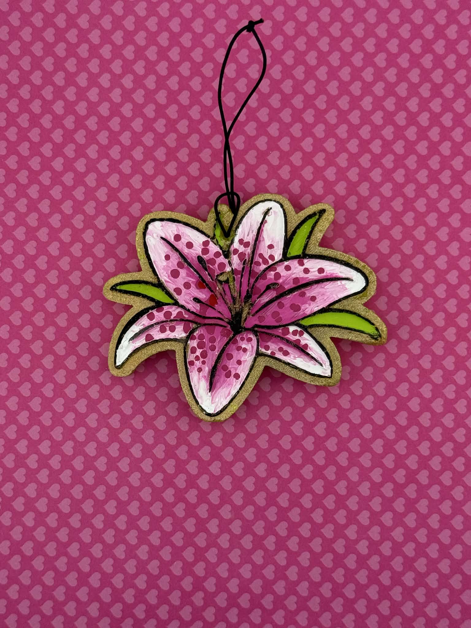 Lily shaped freshie on a pink background with heart patterns