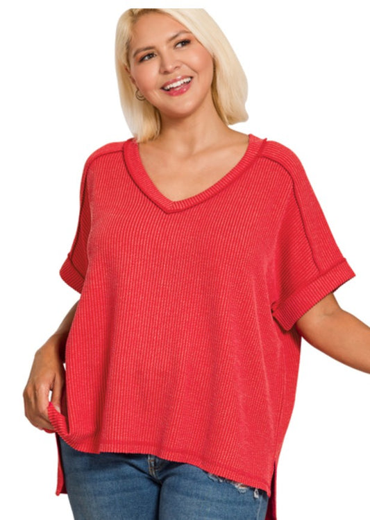 Woman wearing a red ribbed vneck top with a white background