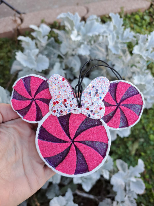Pink and purple candy-themed freshie held in front of a garden background