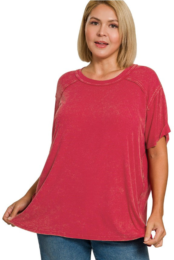 Woman wearing a red ribbed top with a white background