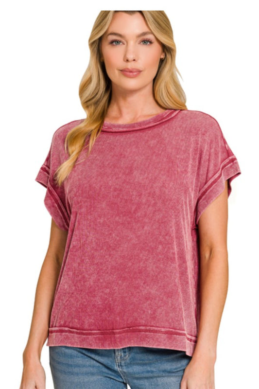 Woman wearing a cabernet red ribbed acid washed top on a white background