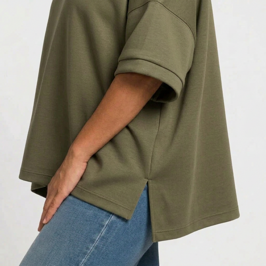 side view of an olive hi low hem top and jeans on a woman