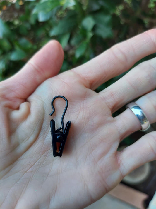 hand holding a black metal vent clip