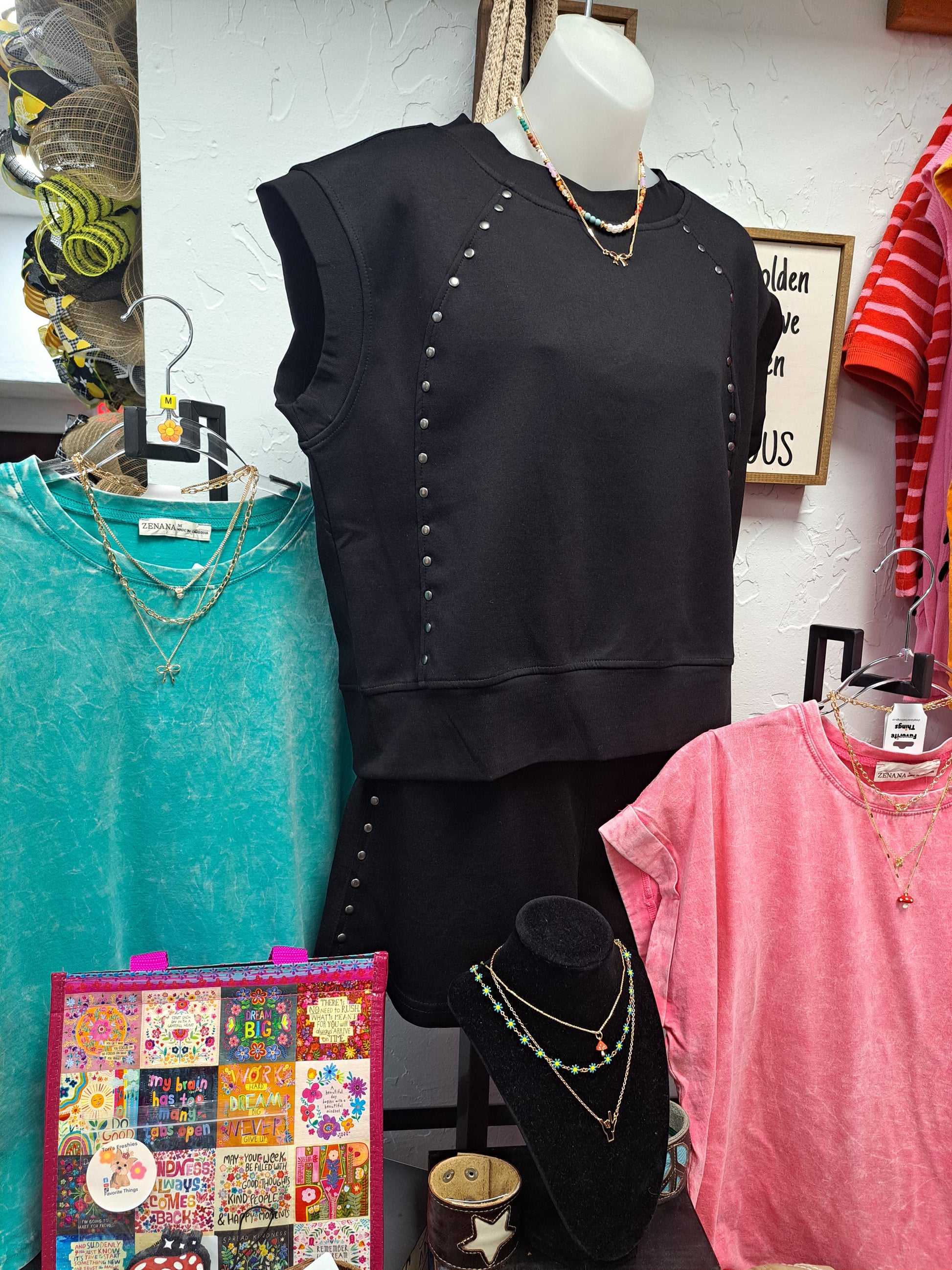 Black top with decorative elements on a white surface with various items around