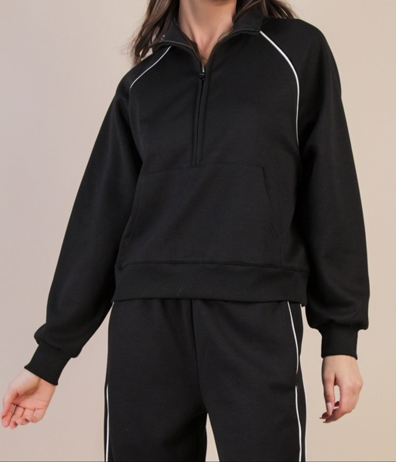 Black tracksuit with white accents on a beige background