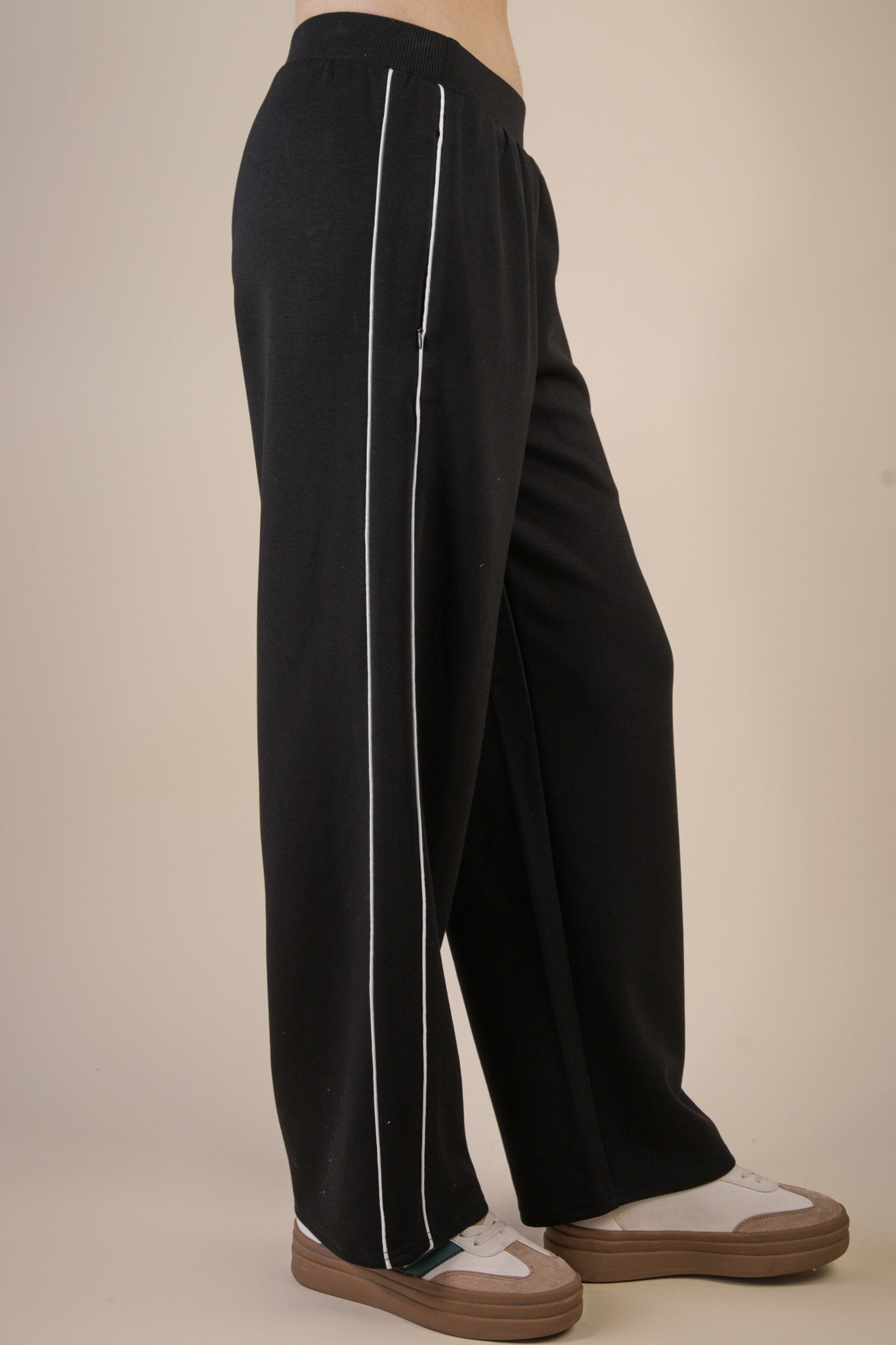 Black pants with white stripes on a beige background
