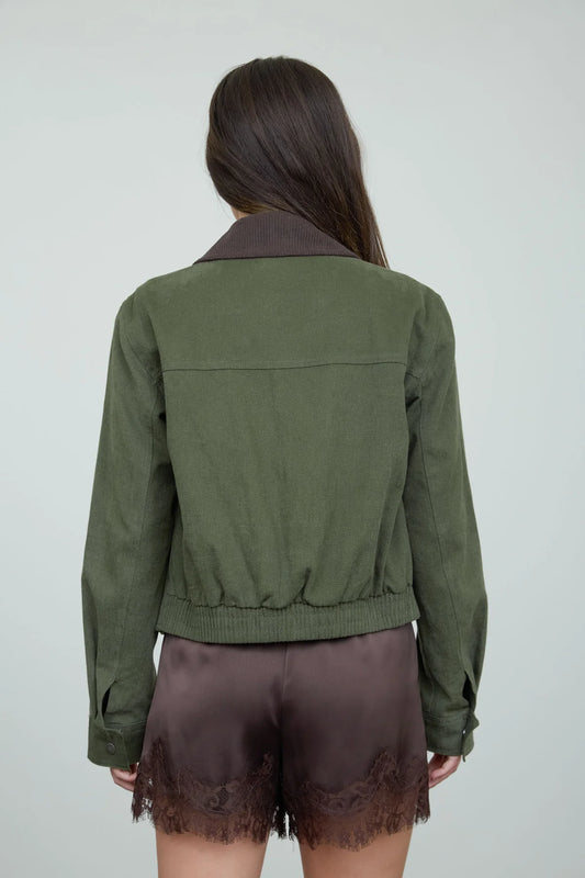back view of an olive jacket on a woman againsta a neutral background