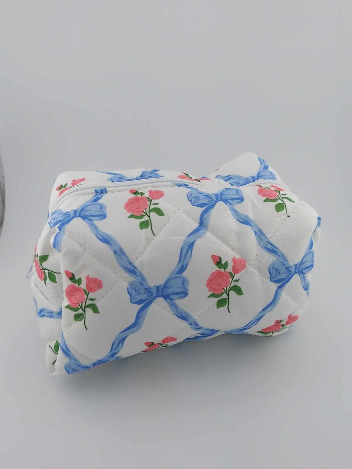 blue bow with roses cosmetic bag on a neutral background