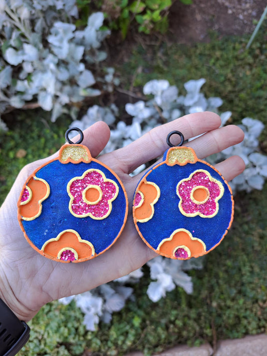 blue bulb vent clips held in hand in front of greenery