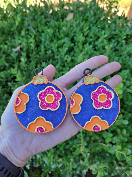 blue bulb vent clips held in front of greenery background