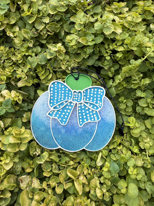 blue pumpkin freshie with polka dot bow. greenery background