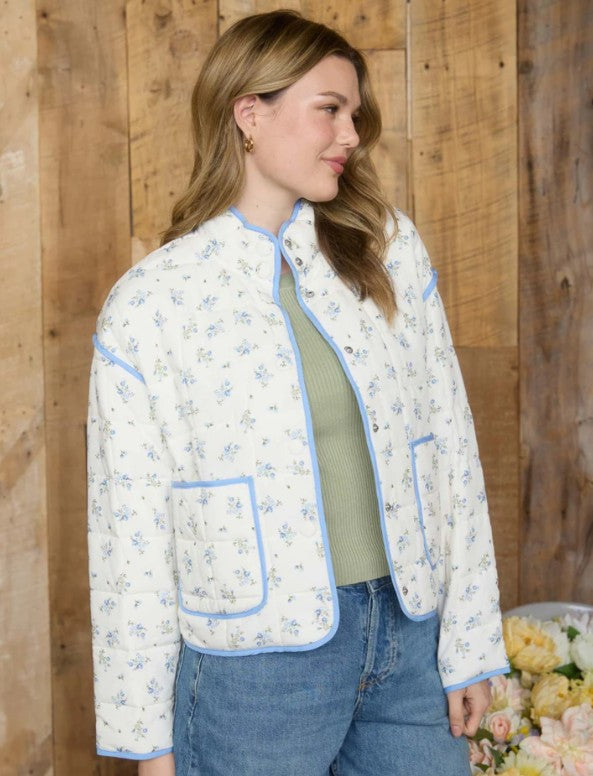 Woman wearing a floral quilted jacket with a wooden background