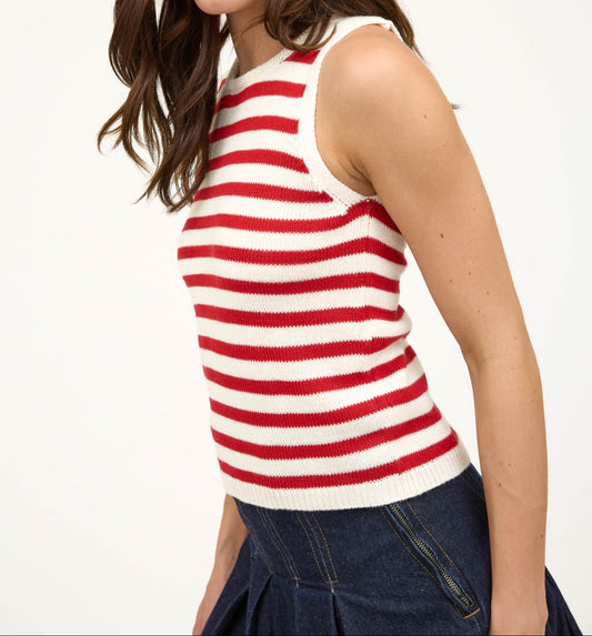 Woman wearing a red and white striped tank top against a plain background. Side view