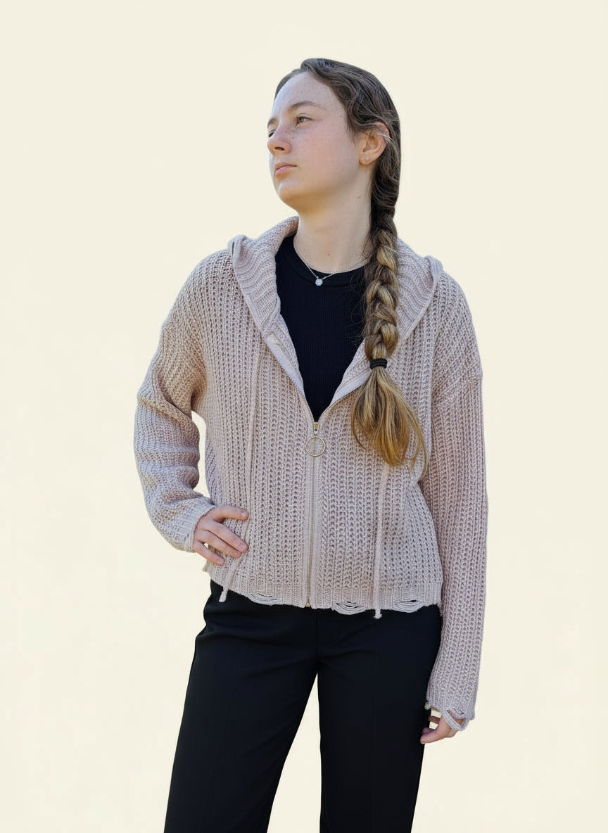 person wearing a blush pink zip front sweater hoodie with black top and pants