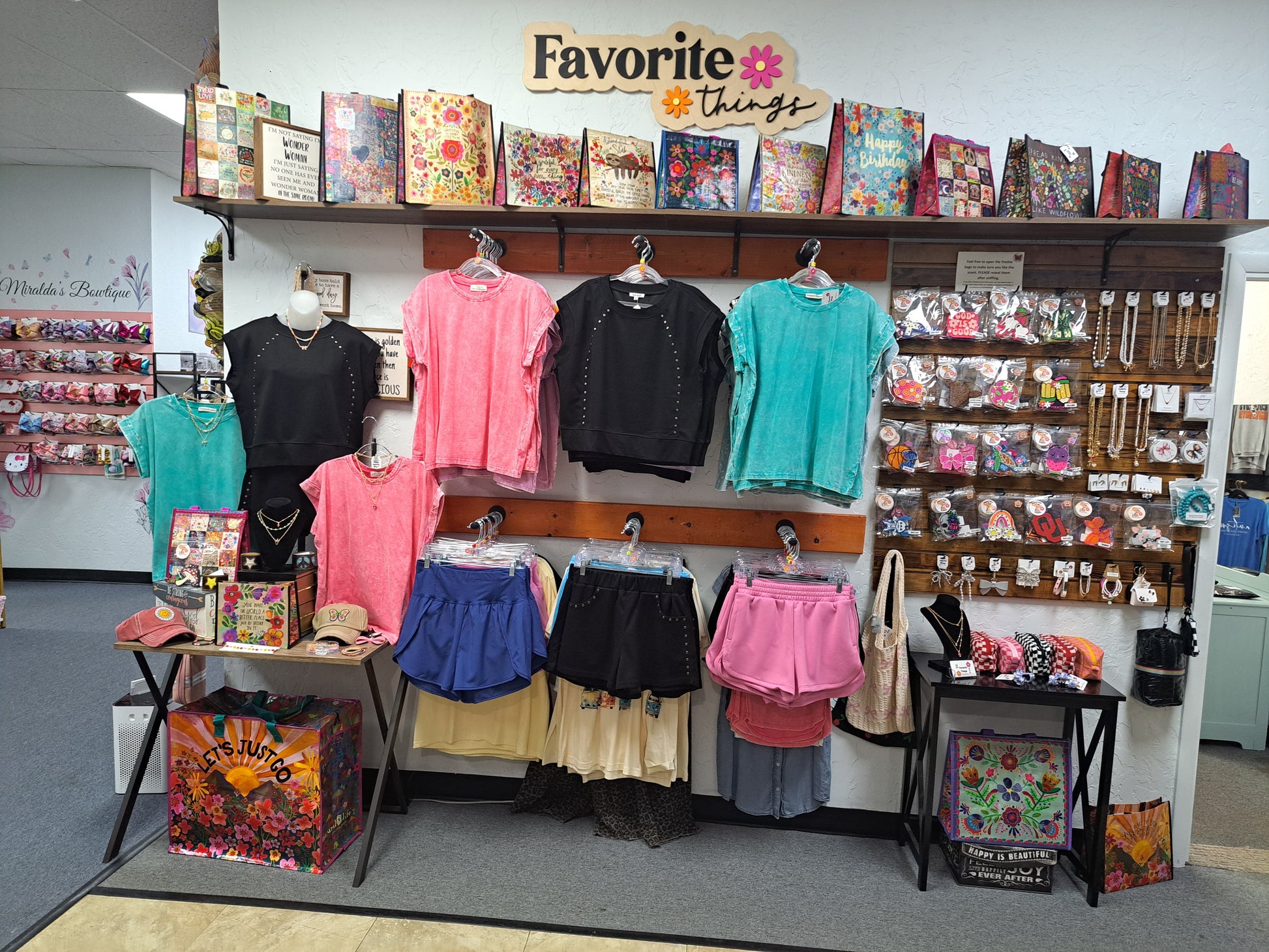 Display of clothing and accessories in a store with 'Favorite Things' sign.