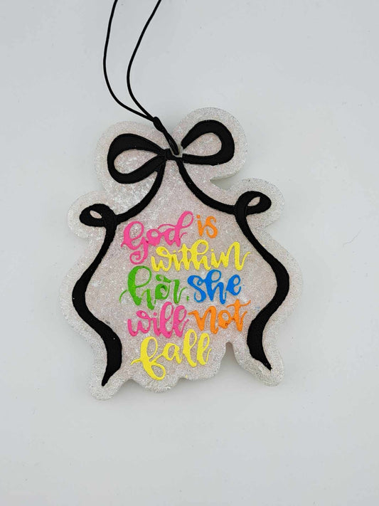 A handmade and painted hanging air freshener with the text 'God is with her' in colorful letters, tied with a black ribbon on an elastic black string.